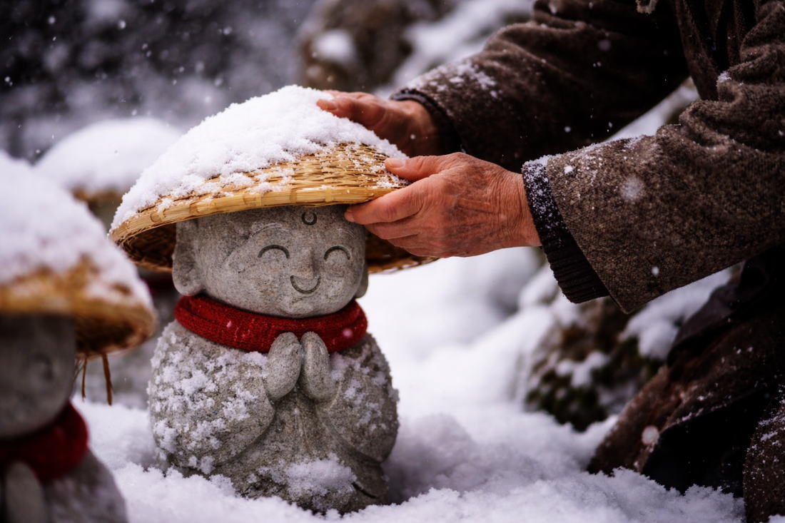 雪の中で笠をかけるやさしさの情景
